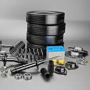 Stack of car tires surrounded by various automotive parts including springs, bearings, and a battery.